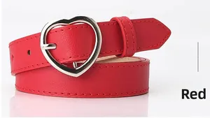 Detailed view of red faux leather belt featuring a silver heart-shaped metal buckle