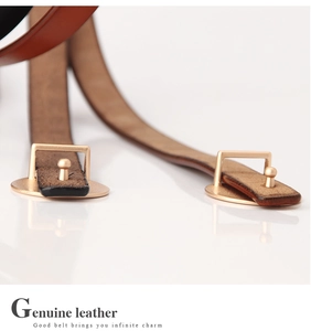 Close-up of elegant genuine leather belt with matte gold oval buckle for women