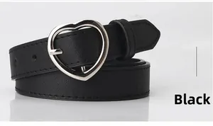 Detail of minimalist black leather belt featuring a polished silver heart-shaped metal buckle