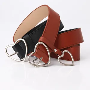 Detail of heart-shaped silver metal buckles on black and brown leather fashion belts