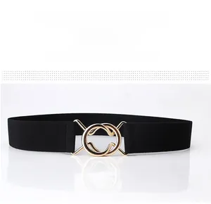 Detail of black elastic cinch belt with interlocking gold round metal buckle for women