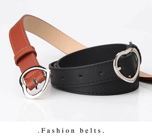 Detail of slim black and brown leather belts with silver heart-shaped metal buckles