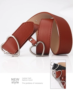 Close-up of stylish women belt with silver heart buckle in brown and black leather