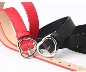 Close-up of red and black women's faux leather belts with silver heart-shaped alloy buckles