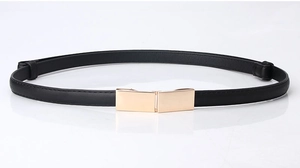 Détail d'une ceinture fine en cuir noir avec une boucle rectangulaire en métal doré