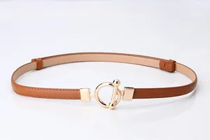 Detail of slim brown leather belt featuring a golden O-ring toggle closure for women