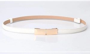 Détail d'une ceinture fine en cuir blanc avec boucle rectangulaire dorée