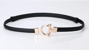 Detail of slim black leather belt with a decorative golden metal toggle clasp