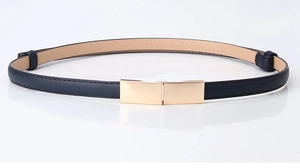 Détail d'une ceinture fine en cuir bleu marine avec boucle dorée rectangulaire et surpiqûres