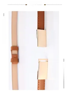 Détail d'une ceinture fine en cuir marron avec boucle rectangulaire dorée et surpiqûres