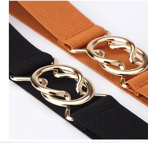 Close-up of black and caramel elastic waist belts with double ring gold metal buckles