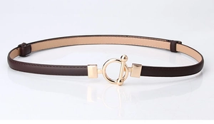 Close-up of slim dark brown leather belt with elegant golden circular metal buckle