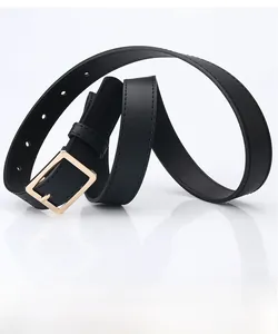 Macro detail of black leather belt with lychee texture and golden rectangular buckle