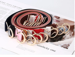 Close-up of elastic waist belts in various colors with golden double ring metal buckles
