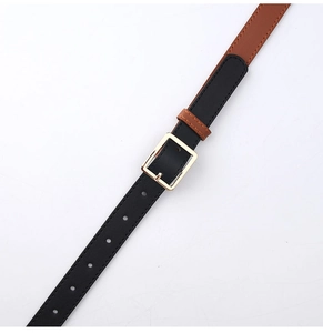 Detail of slim two-tone faux leather belt in black and brown with a gold square buckle