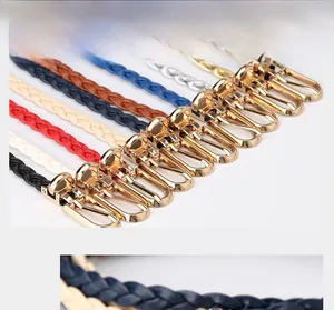 Close-up of multicolored braided leather belts featuring polished gold metal hooks