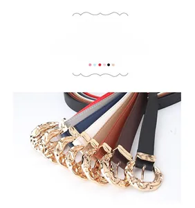 Close-up of stylish leather belts with gold irregular textured round metal buckles in six colors