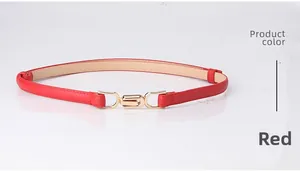 Close-up of elegant red leather belt with minimalist golden metal buckle for women