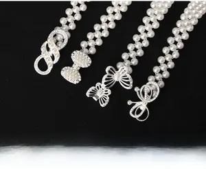 Detail von eleganten Perlen-Taillenketten mit funkelnden silbernen Strass-Schnallen