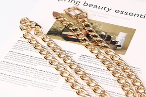 Détail d'une ceinture chaîne dorée avec boucle carrée sur fond de magazine de mode
