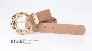 Detail of khaki leather belt with a textured golden irregular ring buckle on white