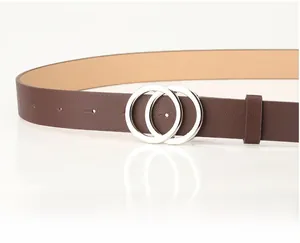 Detail of a dark brown leather belt with minimalist silver double ring buckle closure