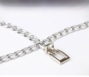 Détail de la ceinture chaîne en métal argenté poli avec une boucle rectangulaire élégante