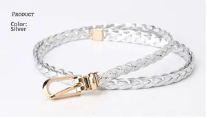 Close-up of silver braided waist belt with metallic finish and gold U-shaped buckle