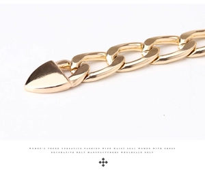 Détail macro de la ceinture en chaîne dorée polie avec un pendentif triangulaire élégant