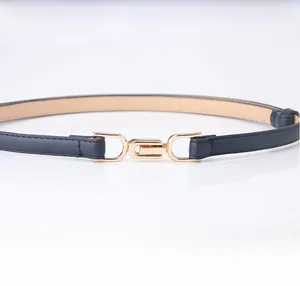 Detail of slim navy blue belt with a sleek gold interlocking buckle for women