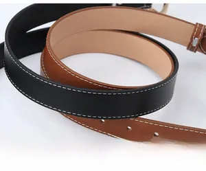 Dettaglio di cinture in pelle nera e marrone con cuciture bianche a contrasto