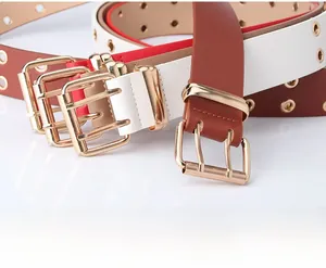 Close-up of double-prong square buckles and metallic eyelets on colorful faux leather belts