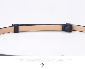 Detailed close-up of dark blue leather belt stitching with light beige inner lining