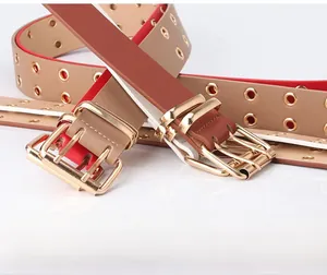 Macro shot of stylish wide belts with golden double-prong buckles and metal eyelets