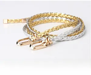 Close-up of woven metallic skinny belts in gold and silver with metal U-buckle detail
