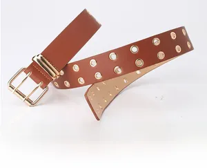 Close-up of brown leather belt with double rows of gold eyelets and dual prong buckle