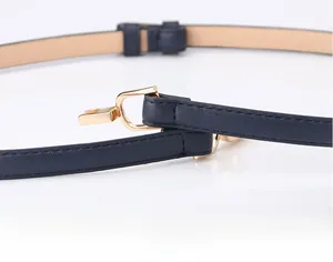Detail shot of navy blue faux leather belt with a polished gold D-ring buckle