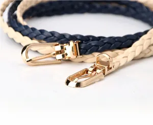 Detail of woven thin waist belts in navy and beige with polished gold alloy buckles