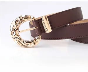 Detailed view of women fashion belt with irregular golden lava metal buckle and brown leather