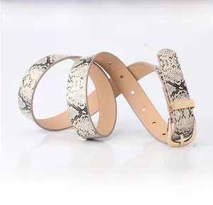 Close-up of women's snakeskin texture belt with golden horseshoe buckle and mirror reflex