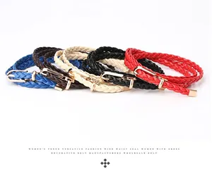 Detail of five multi-color woven skinny belts with gold buckles on a white background