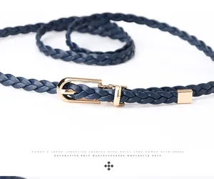 Close-up of dark blue woven belt with gold horseshoe buckle and metallic tip detail