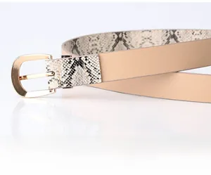 Close-up of gold metal D-buckle and textured snake print detail on woman belt