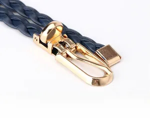 Close-up of a navy blue braided leather belt featuring a polished gold buckle detail