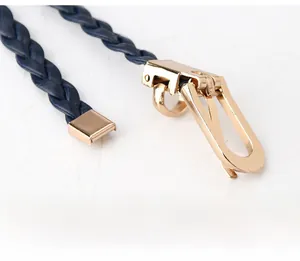 Detail shot of navy blue woven belt for women with a polished gold horseshoe metal buckle