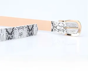 Detailed close-up of a women's belt featuring black and white snake pattern and golden buckle