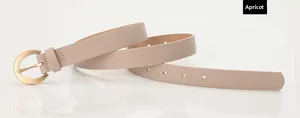 Détail de la ceinture en cuir abricot avec boucle dorée en U et coutures précises