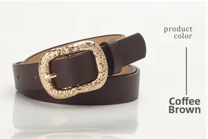 Close-up of dark brown leather belt with vintage floral gold buckle on gray background