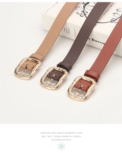 Detailed close-up of three thin leather belts with engraved golden alloy buckles