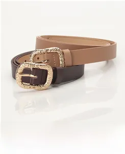 Detail of slim faux leather belts with intricate vintage gold-engraved buckles in two colors